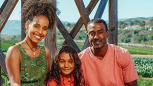 Cheerful family enjoying a day outdoors, set against a lush, rural backdrop.
